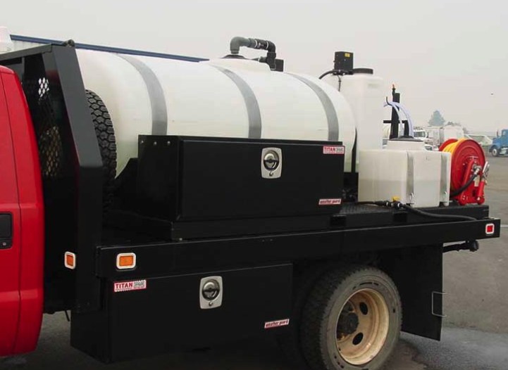 White poly tank mounted on a black flatbed truck body