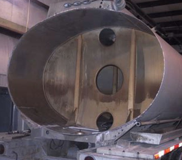 View inside a tank trailer showing welded baffle compartments with access ports